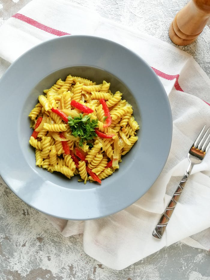 Close-up of a delicious Italian pasta dish with vibrant red peppers, perfect for food photography.